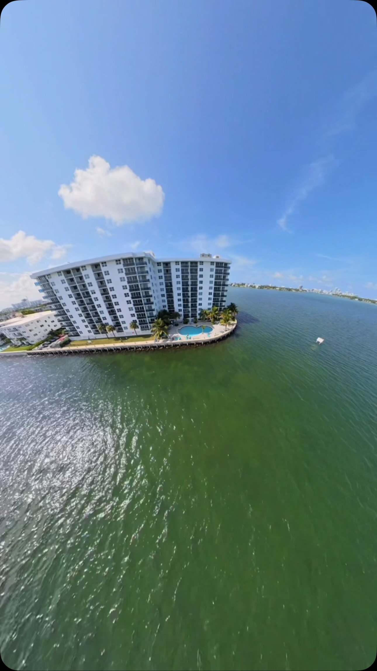 Isla residencial rodeada de agua turquesa desde el aire
